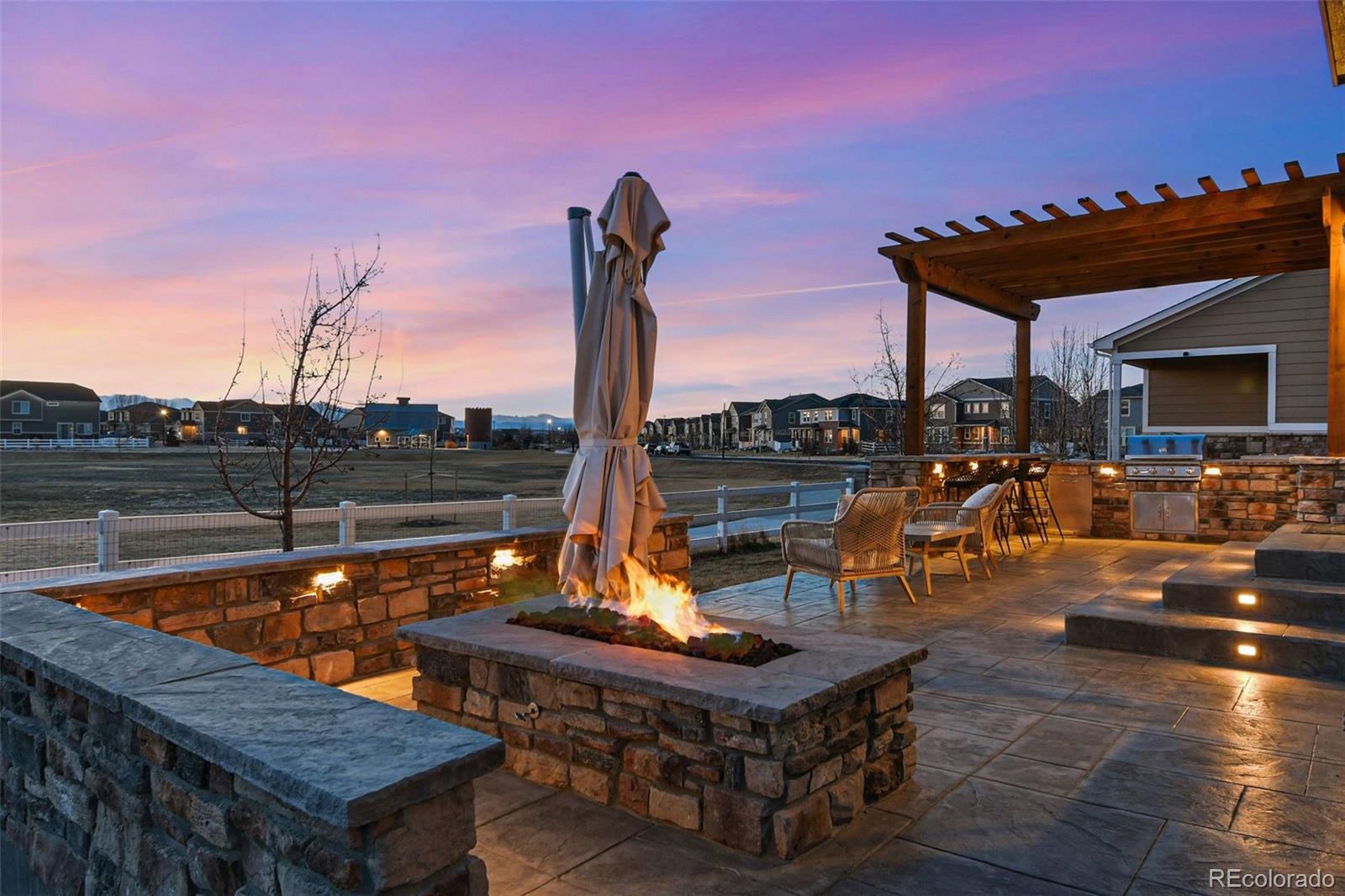 745 Penstemon Drive Henderson, CO 80640 - Photo 24 of 38 a roof deck with table and chairs a barbeque
