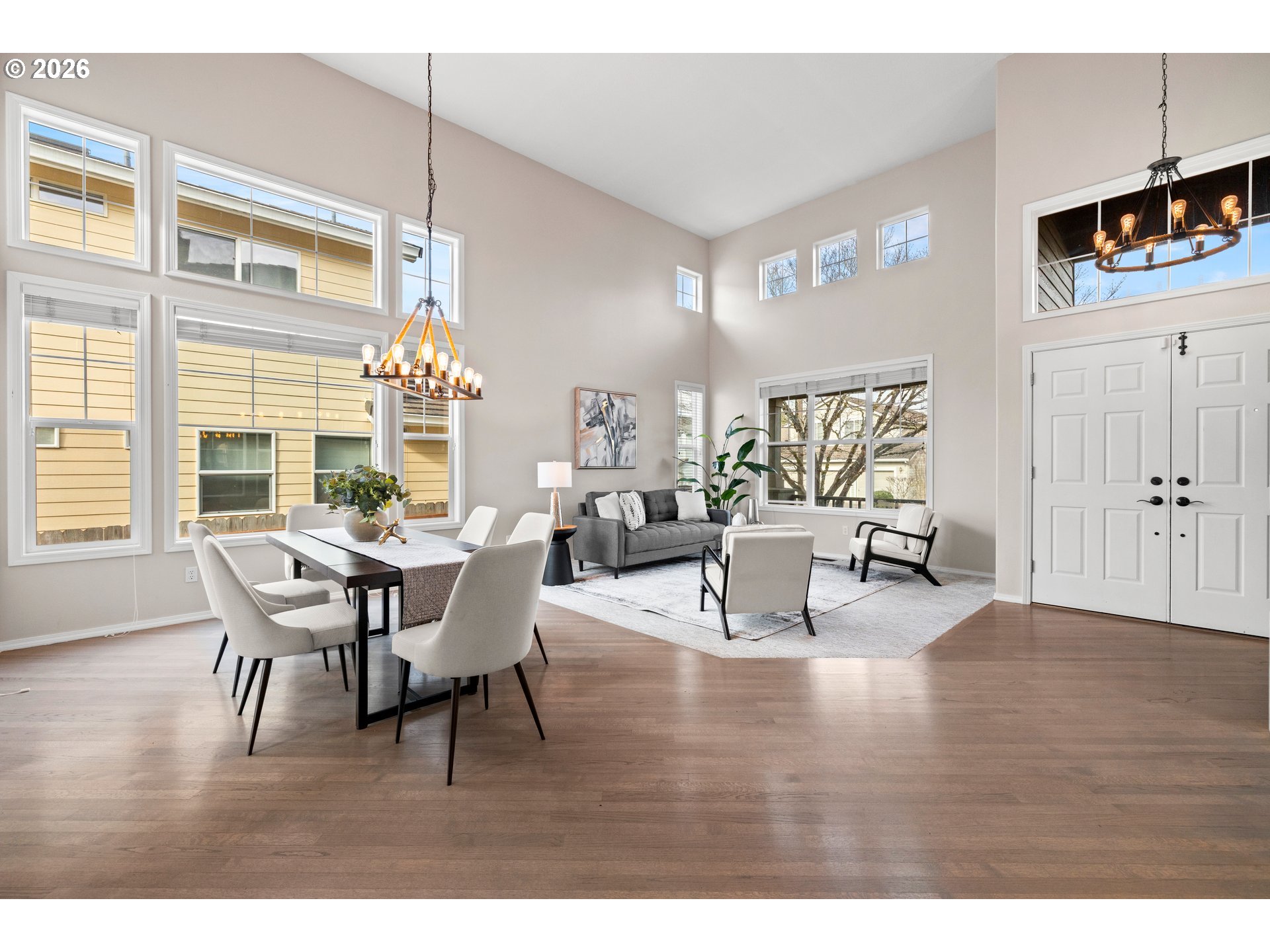 15542 Northwest Andalusian Way Portland, OR 97229 - Photo 7 of 48 a dining room with wooden floor a chandelier a glass table and chairs