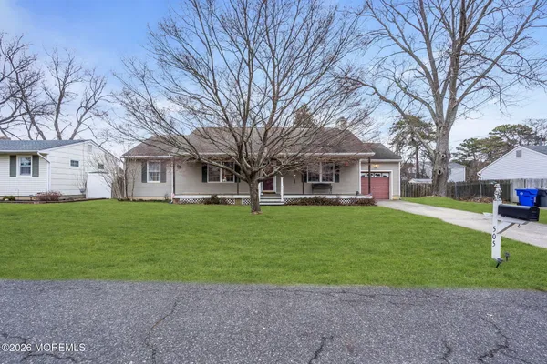 a front view of a house with a garden and trees