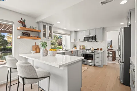 a kitchen with a stove a sink a dining table and chairs