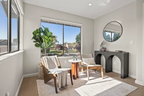 a view of a dining room with furniture a fireplace and wooden floor