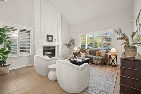 a living room with furniture large window and a fireplace