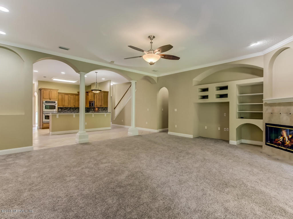 1576 Scott Road Fruit Cove, FL 32259 - Photo 16 of 87 a view of a livingroom with a fireplace and a ceiling fan