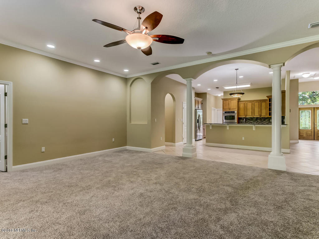 1576 Scott Road Fruit Cove, FL 32259 - Photo 17 of 87 a view of an empty room with a chandelier fan and kitchen view