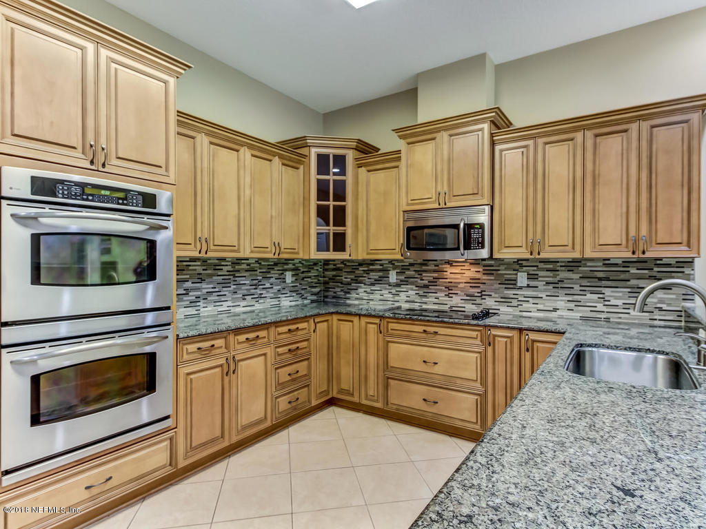 1576 Scott Road Fruit Cove, FL 32259 - Photo 25 of 87 a kitchen with stainless steel appliances granite countertop a stove microwave and cabinets