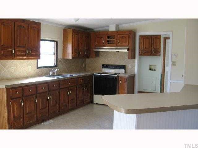 7516 Eagle Run Road Zebulon, NC 27597 - Photo 5 of 11 a kitchen with a sink a stove and cabinets