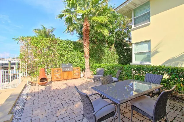 a view of a patio with couches table and chairs and potted plants