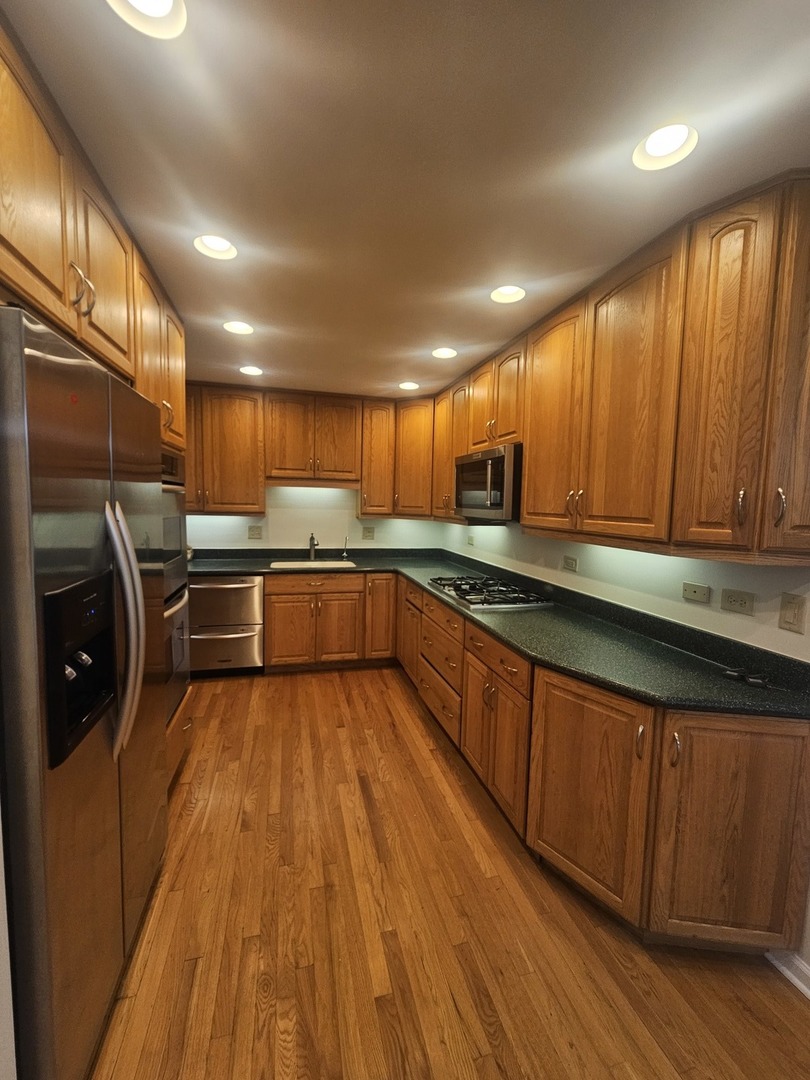 399 Purdue Lane Elgin, IL 60123 - Photo 5 of 24 a kitchen with stainless steel appliances granite countertop wooden cabinets a sink and dishwasher a stove with wooden floors
