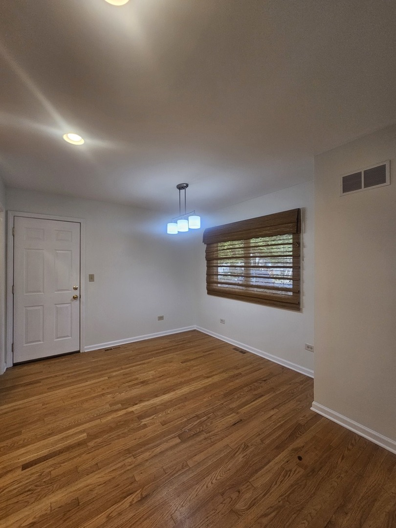 399 Purdue Lane Elgin, IL 60123 - Photo 6 of 24 a view of an empty room with wooden floor and a window