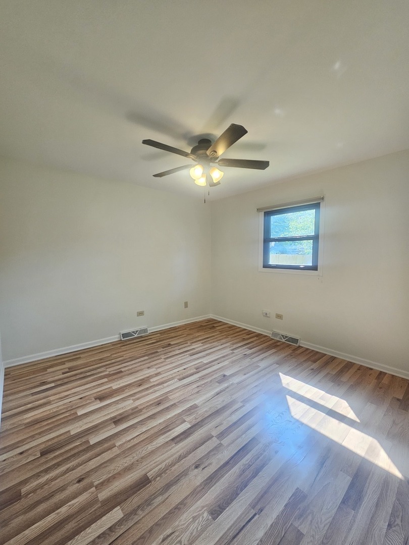 399 Purdue Lane Elgin, IL 60123 - Photo 9 of 24 wooden floor in an empty room with a window