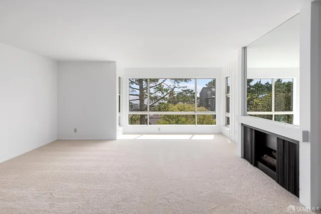 a view of an empty room with a fireplace and a window