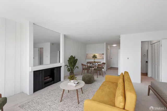 a living room with furniture a table and kitchen view