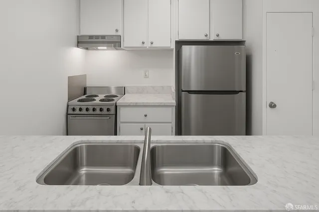 a kitchen with white cabinets and stainless steel appliances