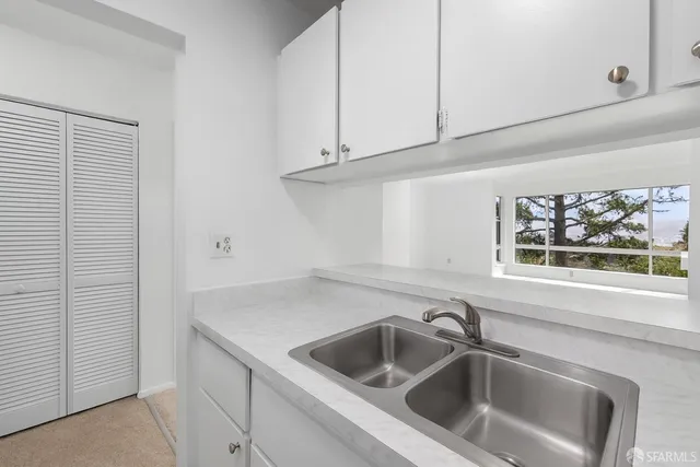 a close view of a sink and dishwasher with cabinets