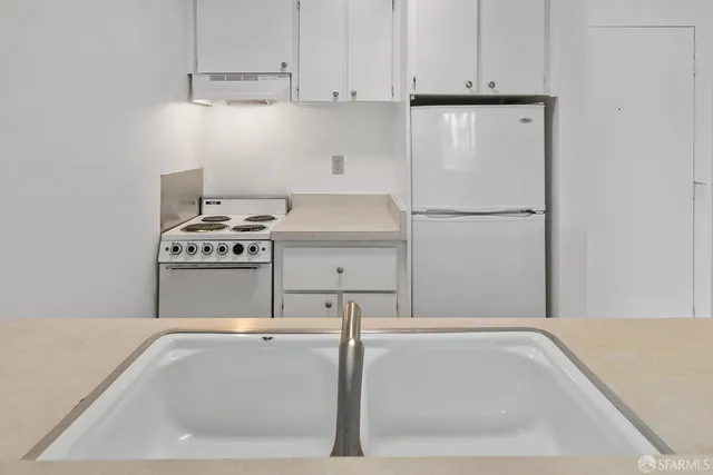 a white refrigerator freezer and a stove sitting inside of a kitchen