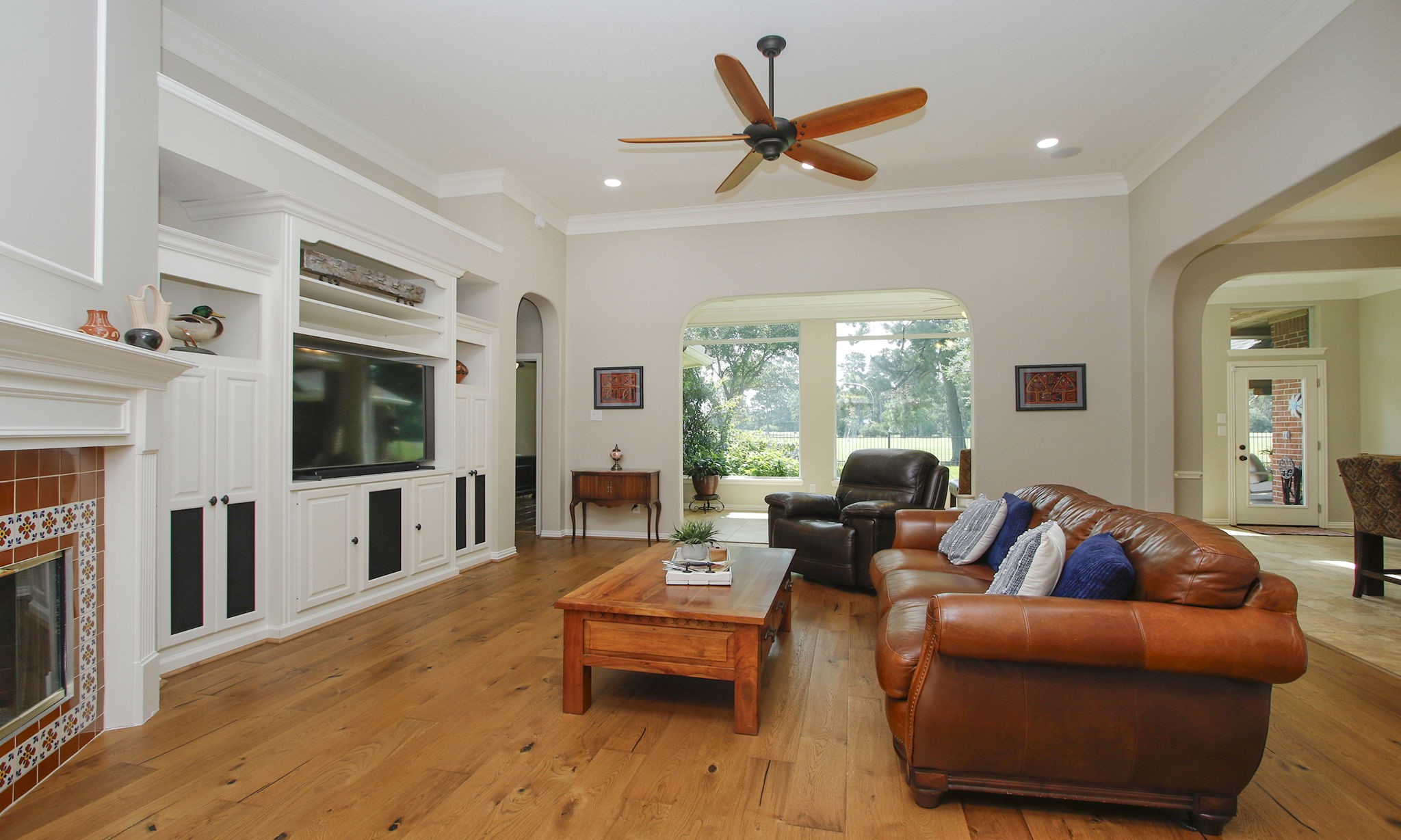 20110 Stormy Pine Lane Spring, TX 77379 - Photo 12 of 44 Spacious family room with beautifully crafted built-in, tall ceilings and gas fireplace with custom tile surround offers both comfort and style! Primary suite sits to the back of the home on the left.