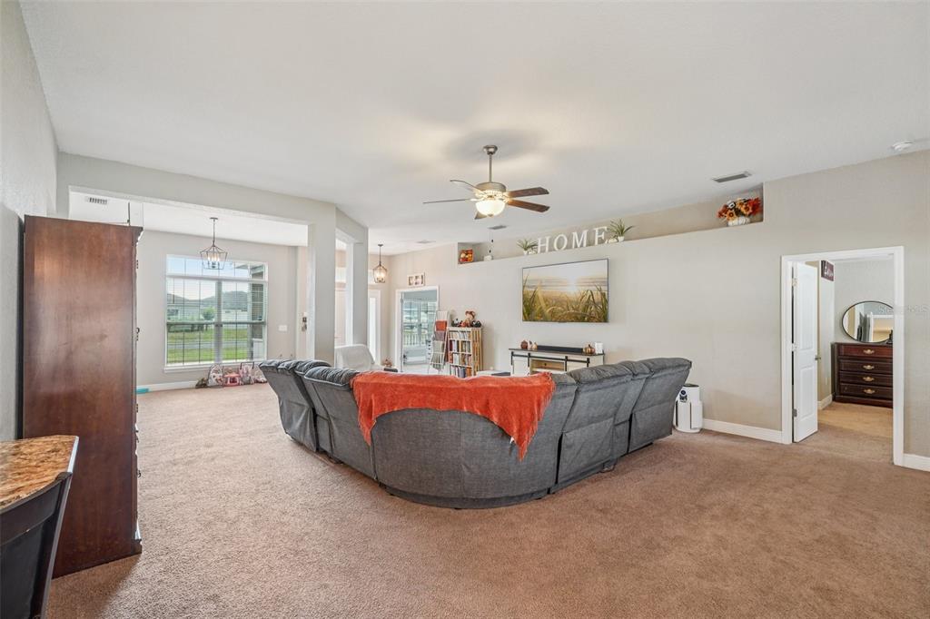 9846 Southwest 55th Ave Road Ocala, FL 34476 - Photo 5 of 25 a living room with furniture a flat screen tv and a refrigerator