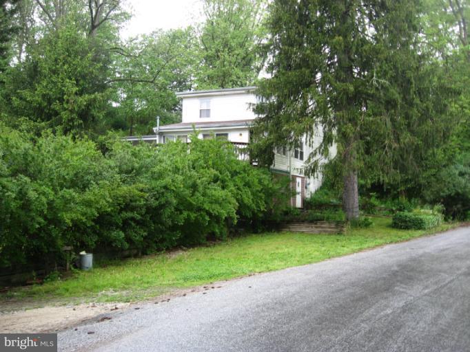 a view of a house with a yard and a tree