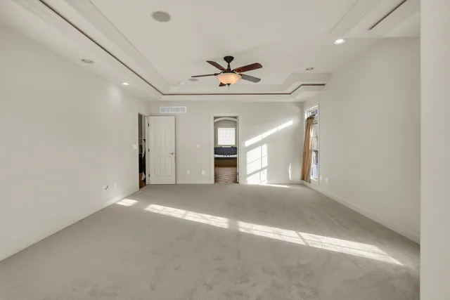 a spacious bedroom with a bed and a chandelier