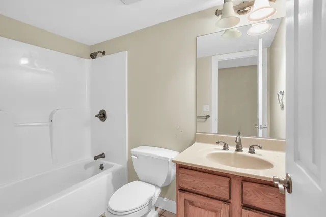 a view of a bedroom with a bed and wooden floor