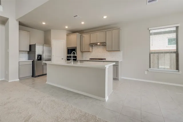 a kitchen with stainless steel appliances white cabinets and a refrigerator