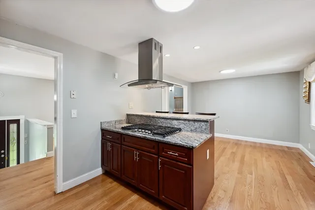 a kitchen with a stove and wooden floor