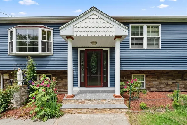 a front view of a house with a yard and potted plants