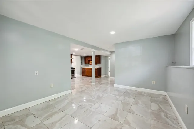 a view of an empty room with a cabinet and kitchen view