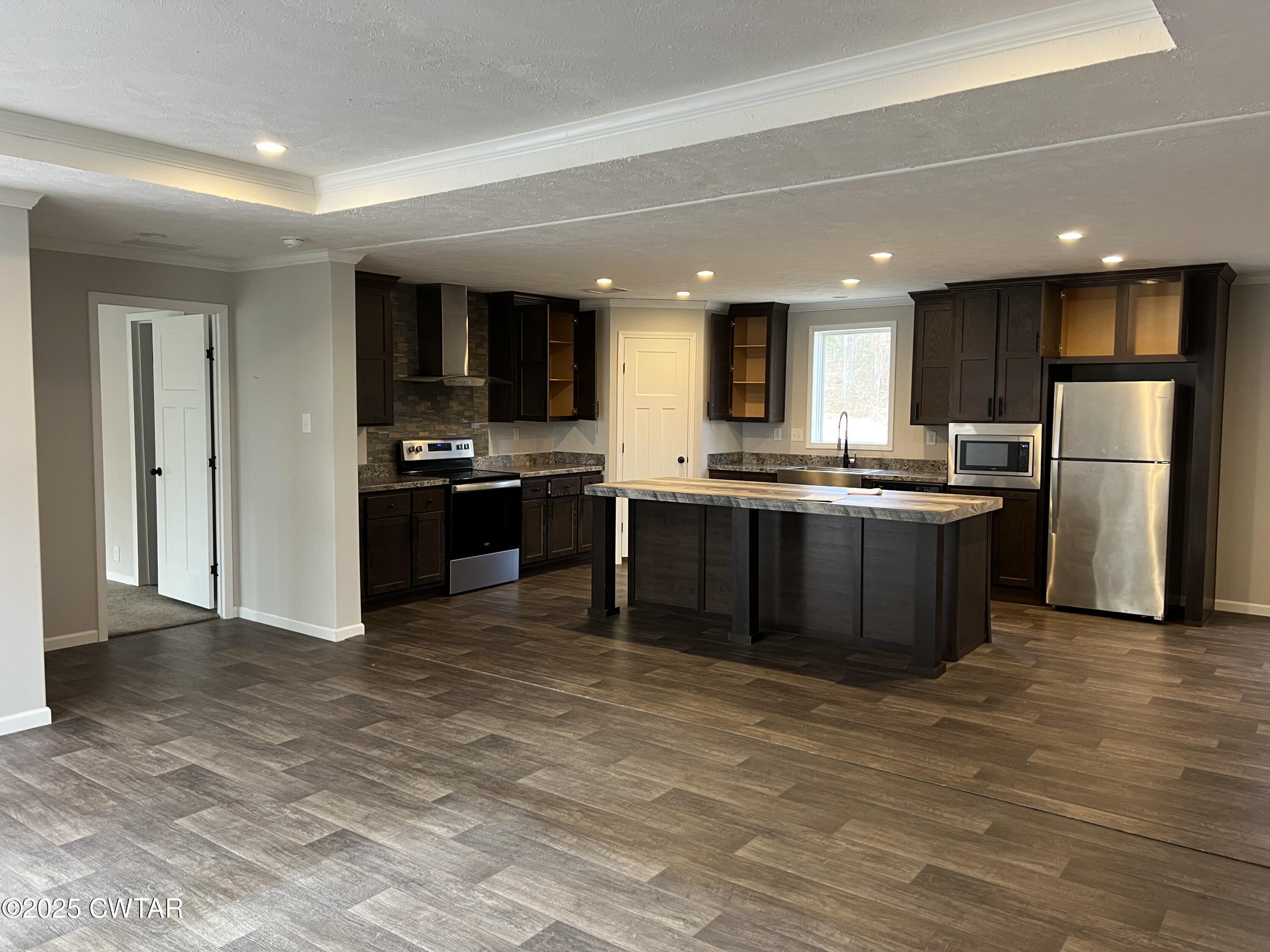 80 Simmons Road Pinson, TN 38366 - Photo 9 of 32 a kitchen with stainless steel appliances granite countertop a stove top oven a sink and a refrigerator