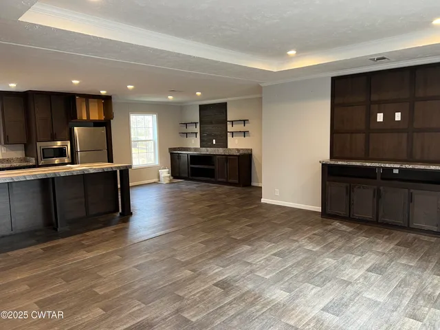 a large kitchen with stainless steel appliances a large counter top and a stove