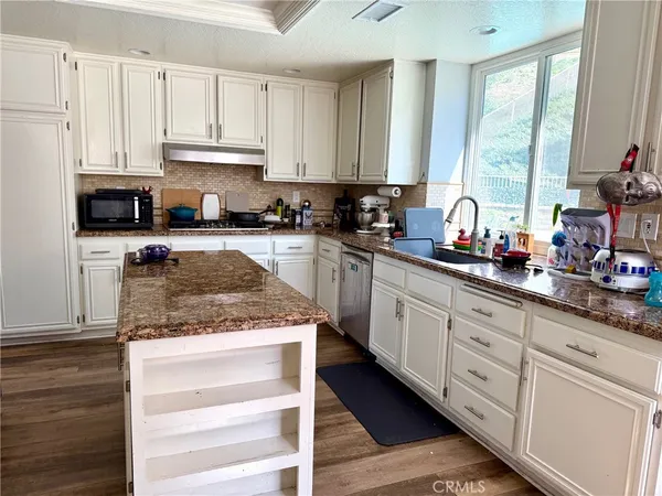 a kitchen with granite countertop white cabinets and white appliances