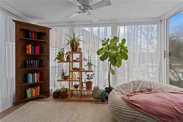 a bedroom with a bed a book shelf and a window