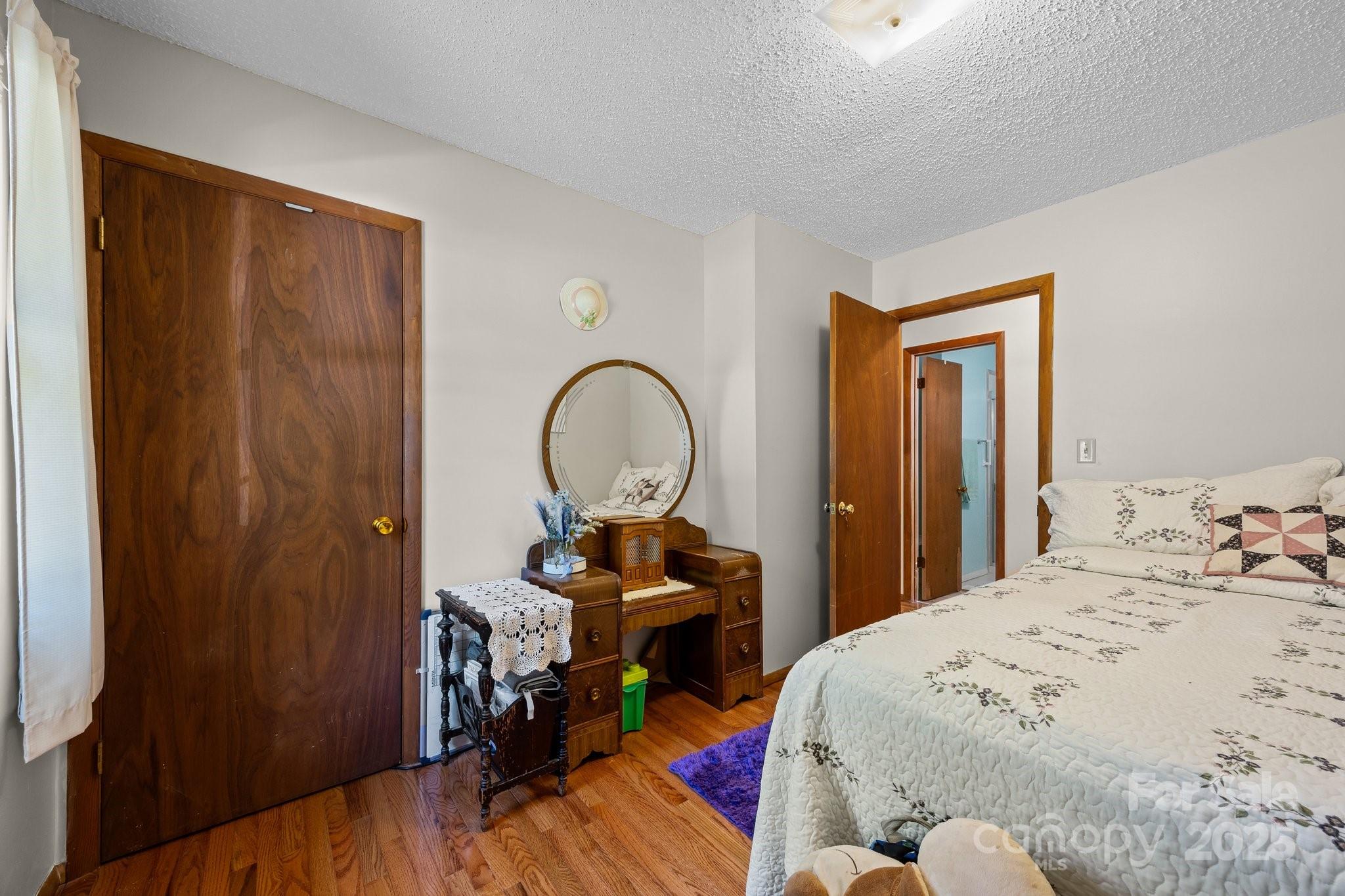 204 Cedar Hill Road Asheville, NC 28806 - Photo 15 of 25 a bedroom with a bed and a chandelier
