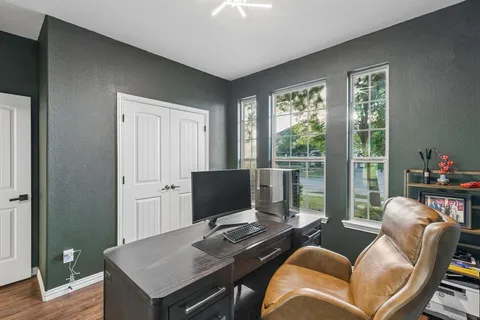 a view of a workspace with furniture and a window