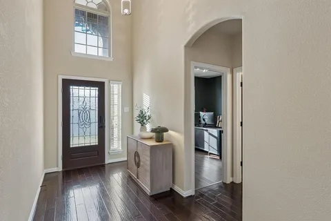 a hallway with dining room and wooden floor
