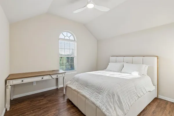 a large bed sitting in a bedroom next to a window with wooden floor