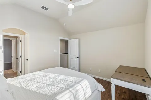 a bedroom with a bed and a ceiling fan