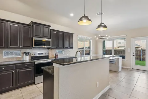 a kitchen with stainless steel appliances granite countertop a sink and stove top oven