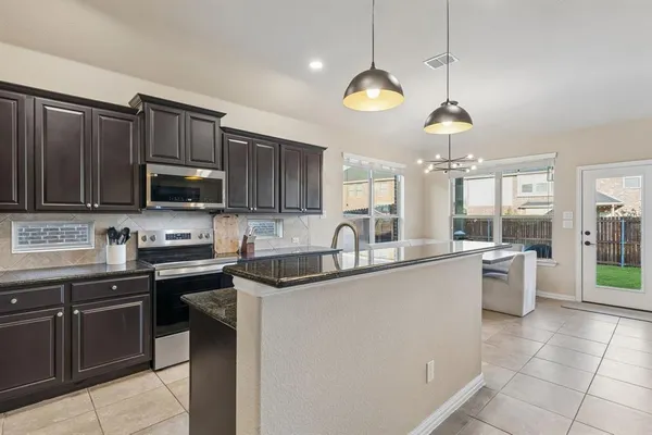 a kitchen with stainless steel appliances granite countertop a sink and stove top oven