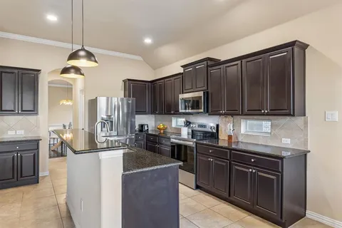 a kitchen with stainless steel appliances granite countertop a sink stove and microwave
