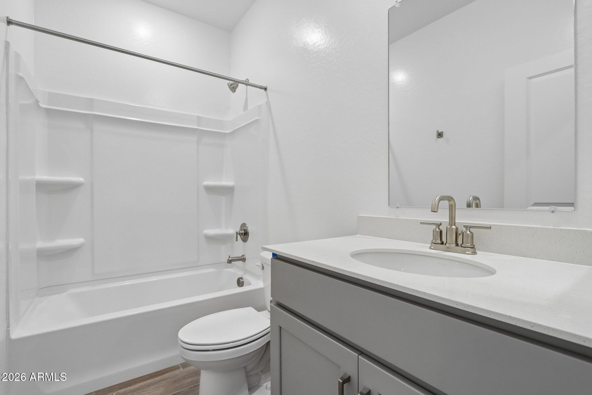 9544 West Gaby Road Tolleson, AZ 85353 - Photo 31 of 43 a bathroom with a sink a toilet and a mirror