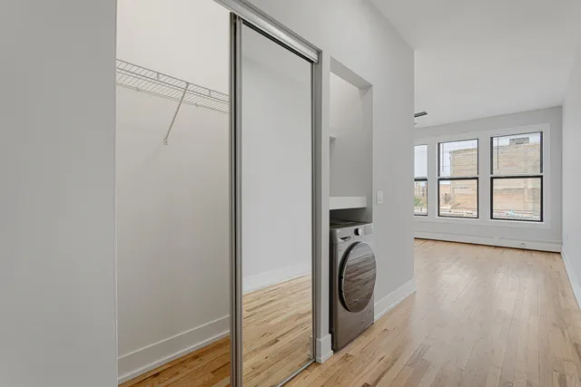 a view of a hallway with wooden floor and entryway
