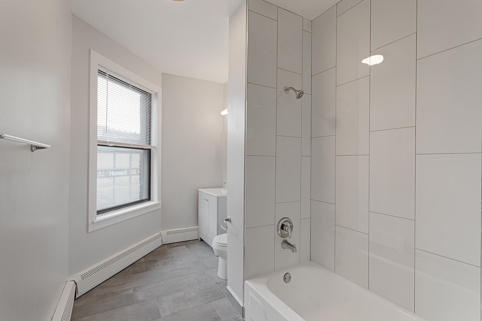 1625 West Howard Street, Unit 219 Chicago, IL 60626 - Photo 8 of 10 a bathroom with a bathtub a toilet and a window