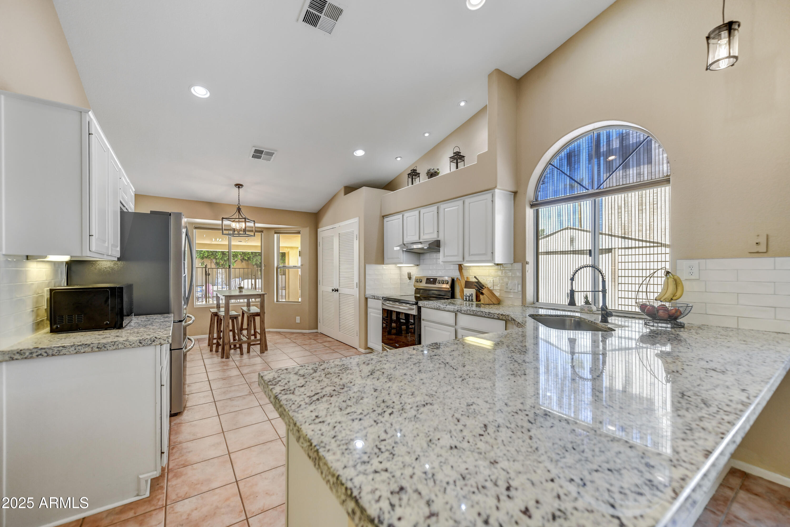 2015 East Bendix Drive Tempe, AZ 85283 - Photo 9 of 31 a kitchen with stainless steel appliances granite countertop a stove top oven a sink a dining table and chairs