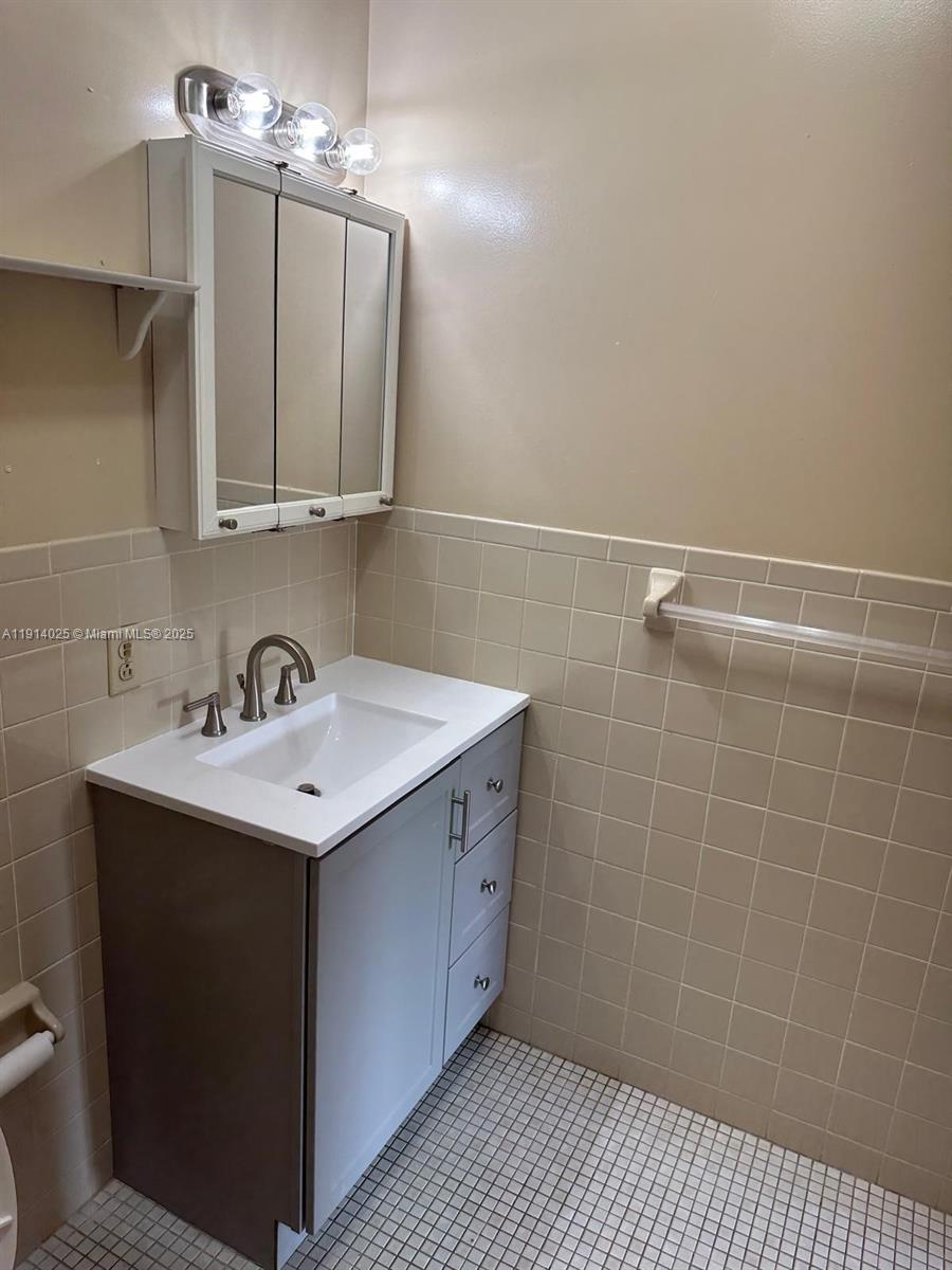 9101 Southwest 88th Street, Unit 1 Miami, FL 33173 - Photo 7 of 10 a bathroom with a sink a toilet and a mirror