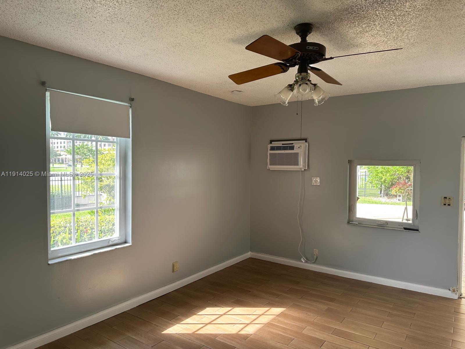 9101 Southwest 88th Street, Unit 1 Miami, FL 33173 - Photo 8 of 10 a view of empty room with wooden floor and fan