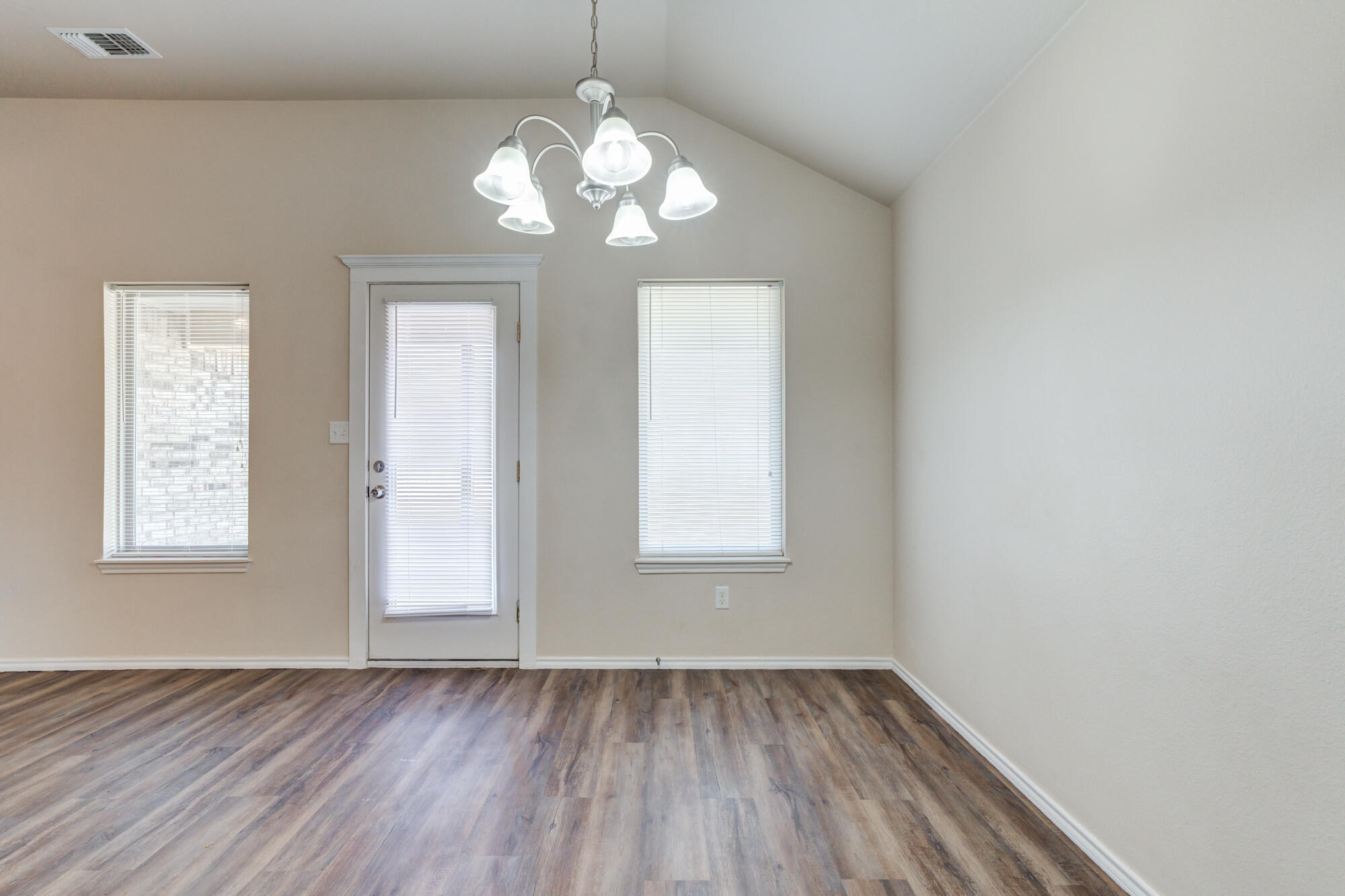 7518 87th Street Lubbock, TX 79424 - Photo 12 of 36 an empty room with wooden floor and windows