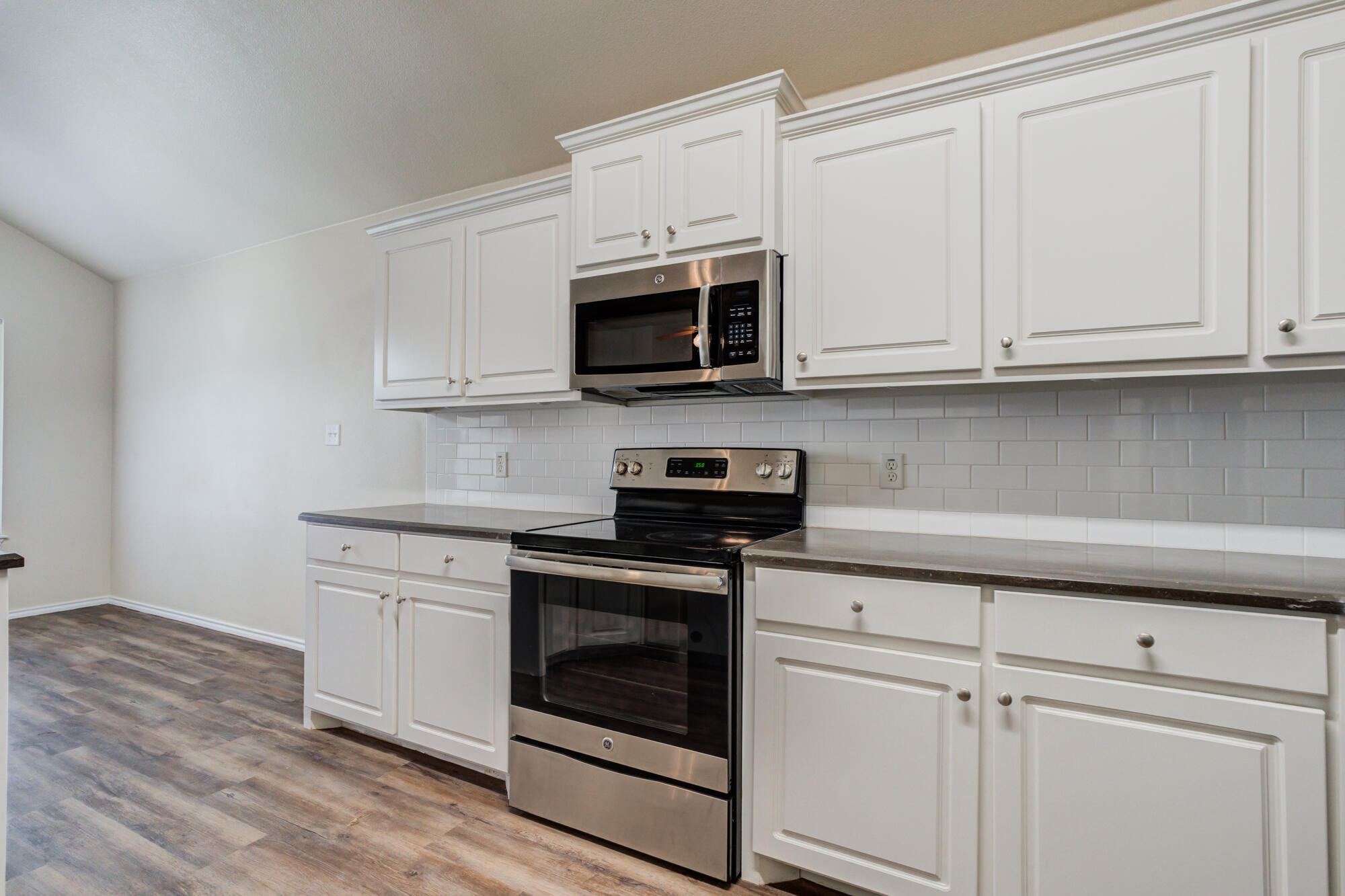 7518 87th Street Lubbock, TX 79424 - Photo 15 of 36 a kitchen with white cabinets and stainless steel appliances