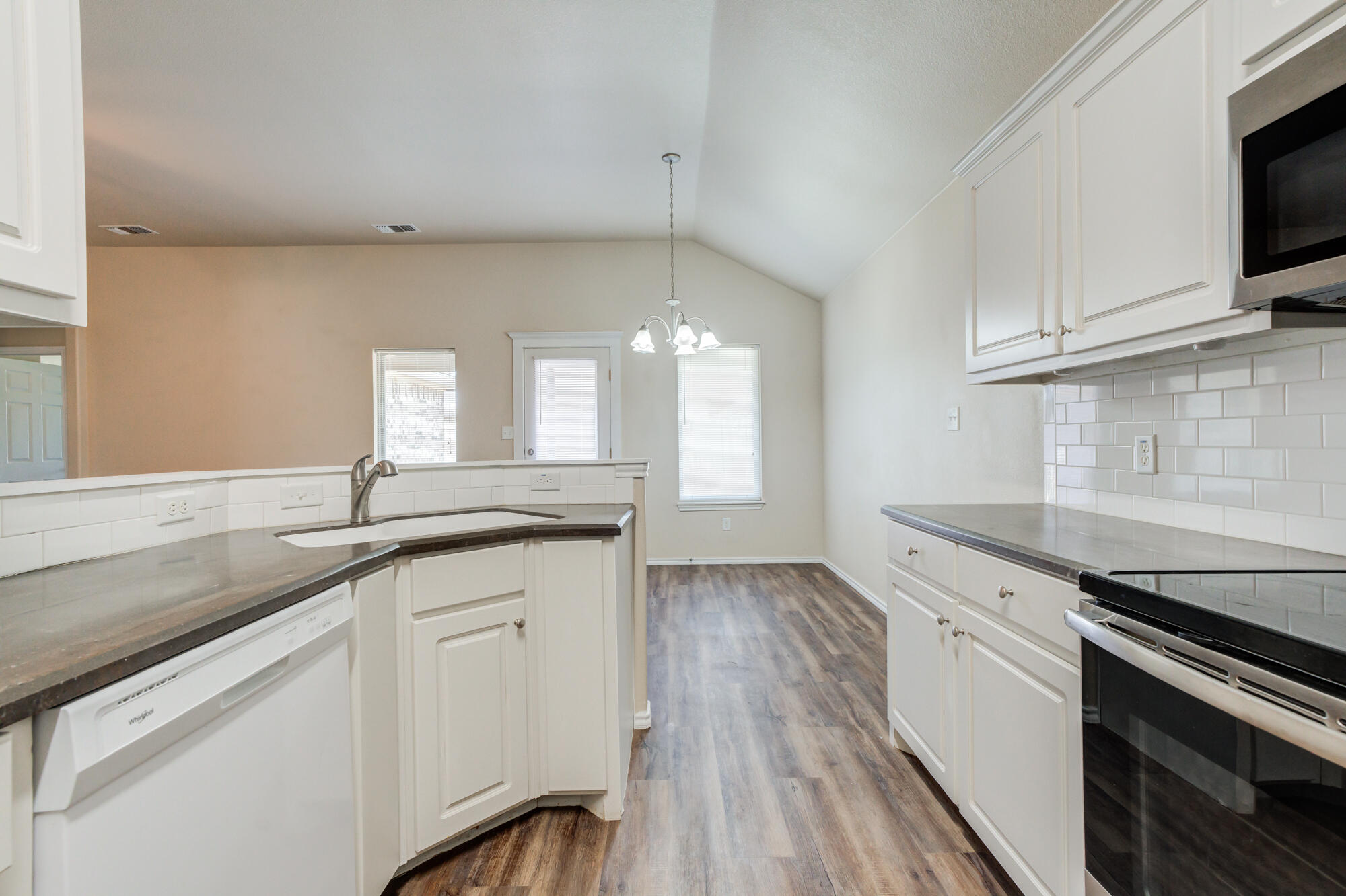 7518 87th Street Lubbock, TX 79424 - Photo 16 of 36 a kitchen with granite countertop white cabinets and white appliances