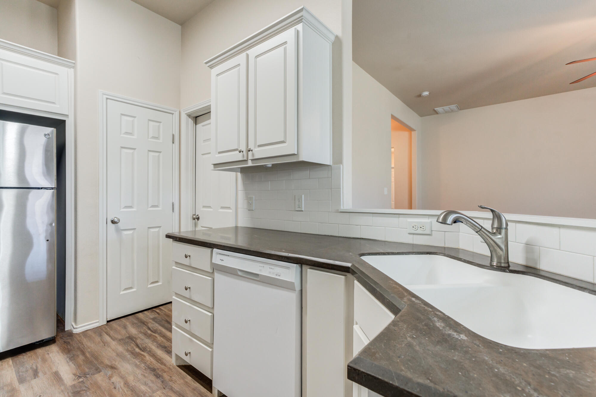 7518 87th Street Lubbock, TX 79424 - Photo 17 of 36 a kitchen with granite countertop white cabinets and refrigerator